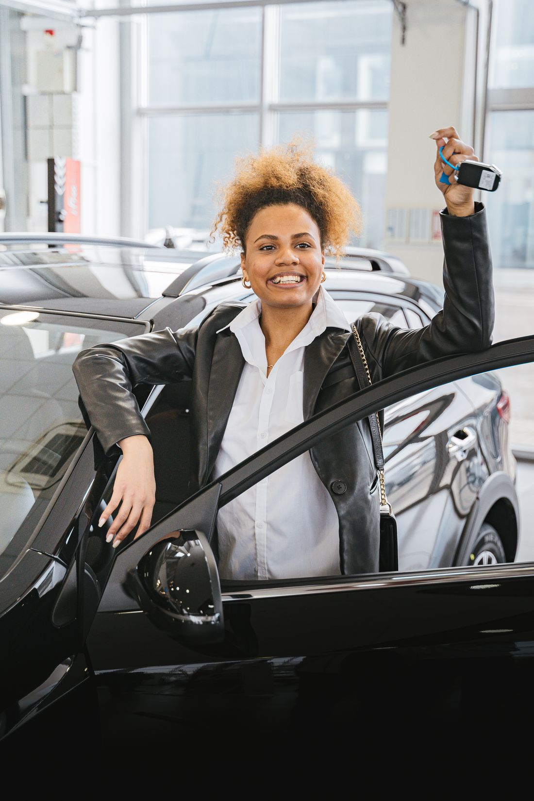 A new driver holding up her car keys after passing her test