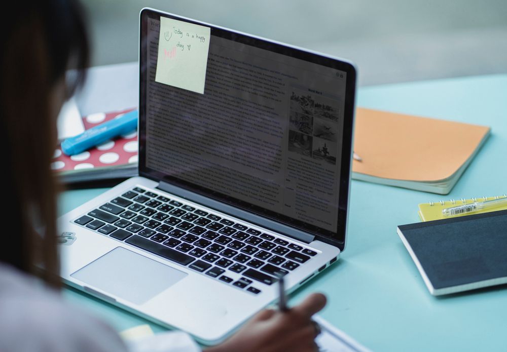 A student revising theory test material at a laptop